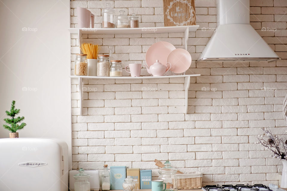 Festive winter cozy kitchen interior with garlands, decorations and gifts.  Christmas dinner at the decorated table.