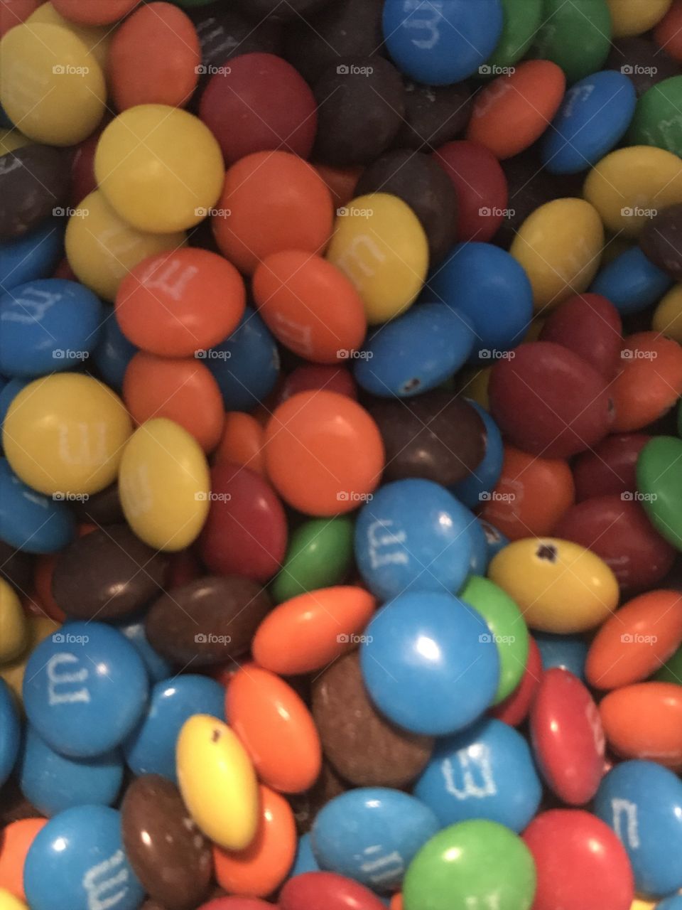 A rainbow pile of M&M’s, some chipped