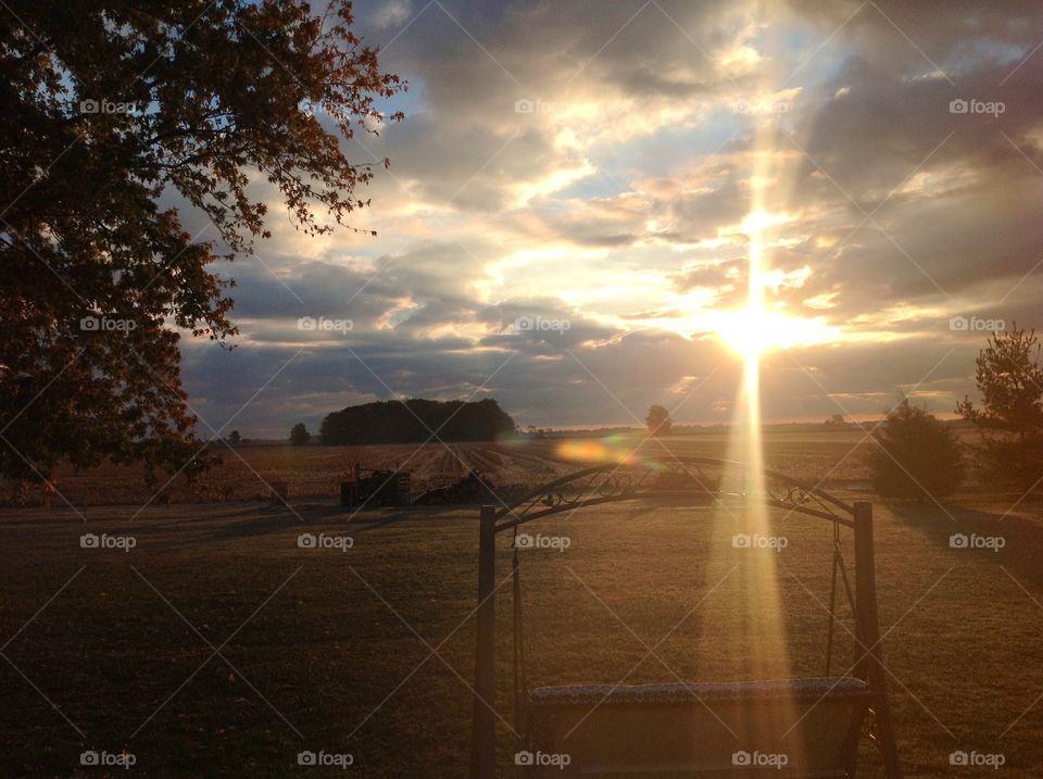 View of empty swing on landscape during sunset