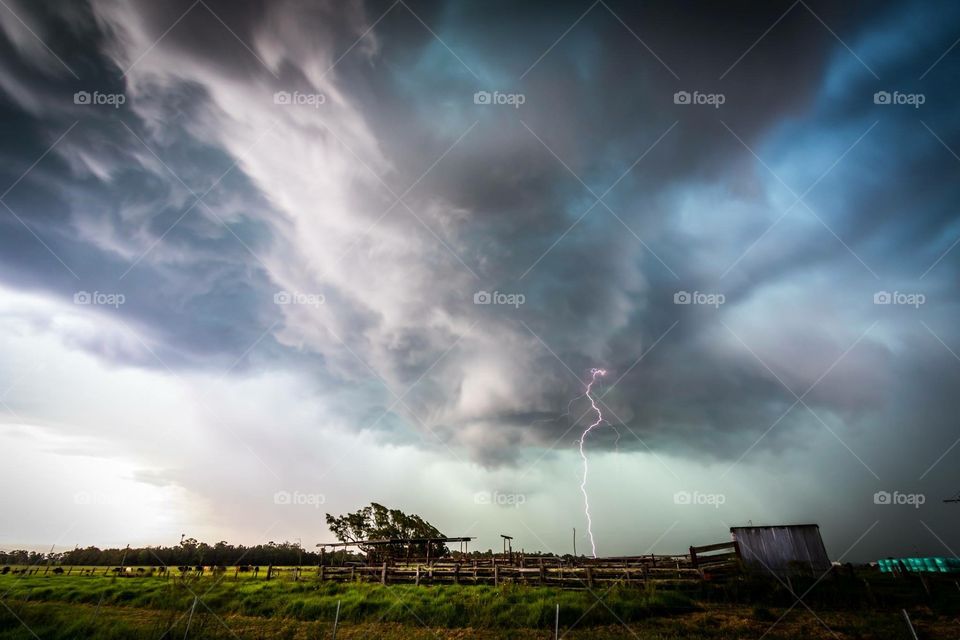 Lightning storm with dramatic clouds over rural land