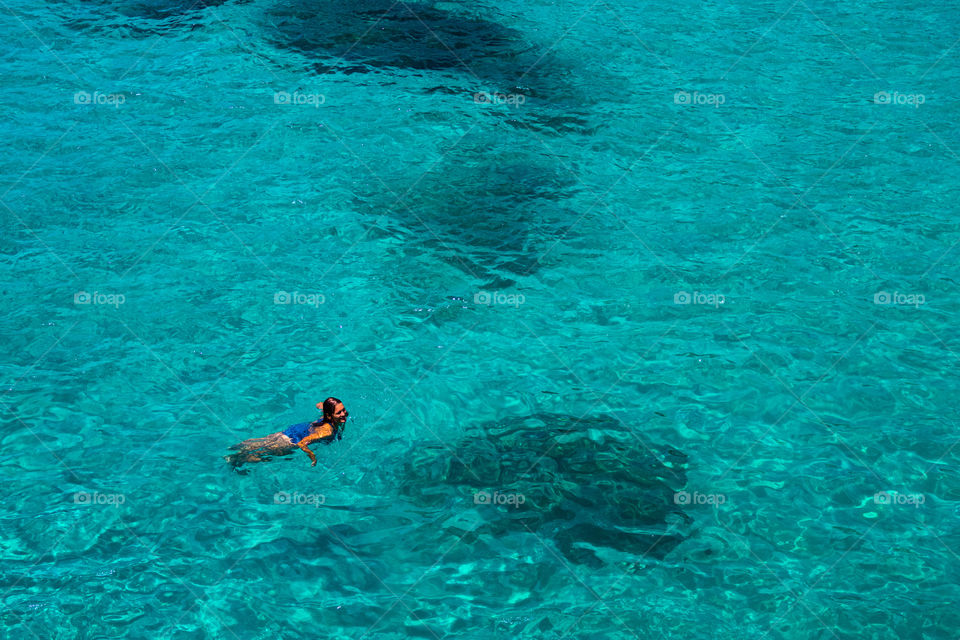 Women swimming in the blue clear tropical ocean 