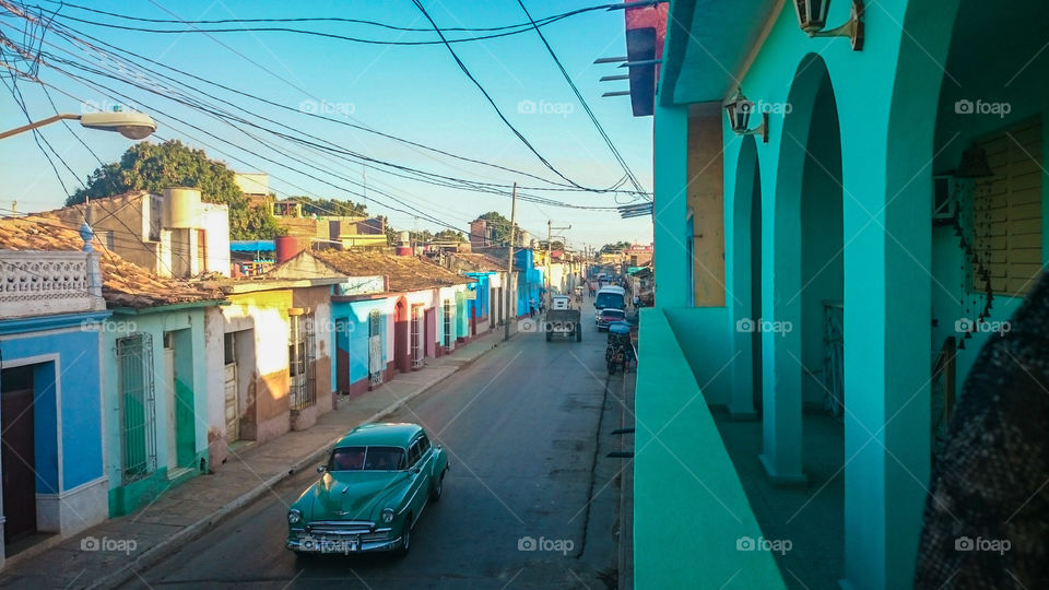 Colorful Houses and Old Cars in Cuba. A 1950s American car makes its way down the street in Trinidad, Cuba.
