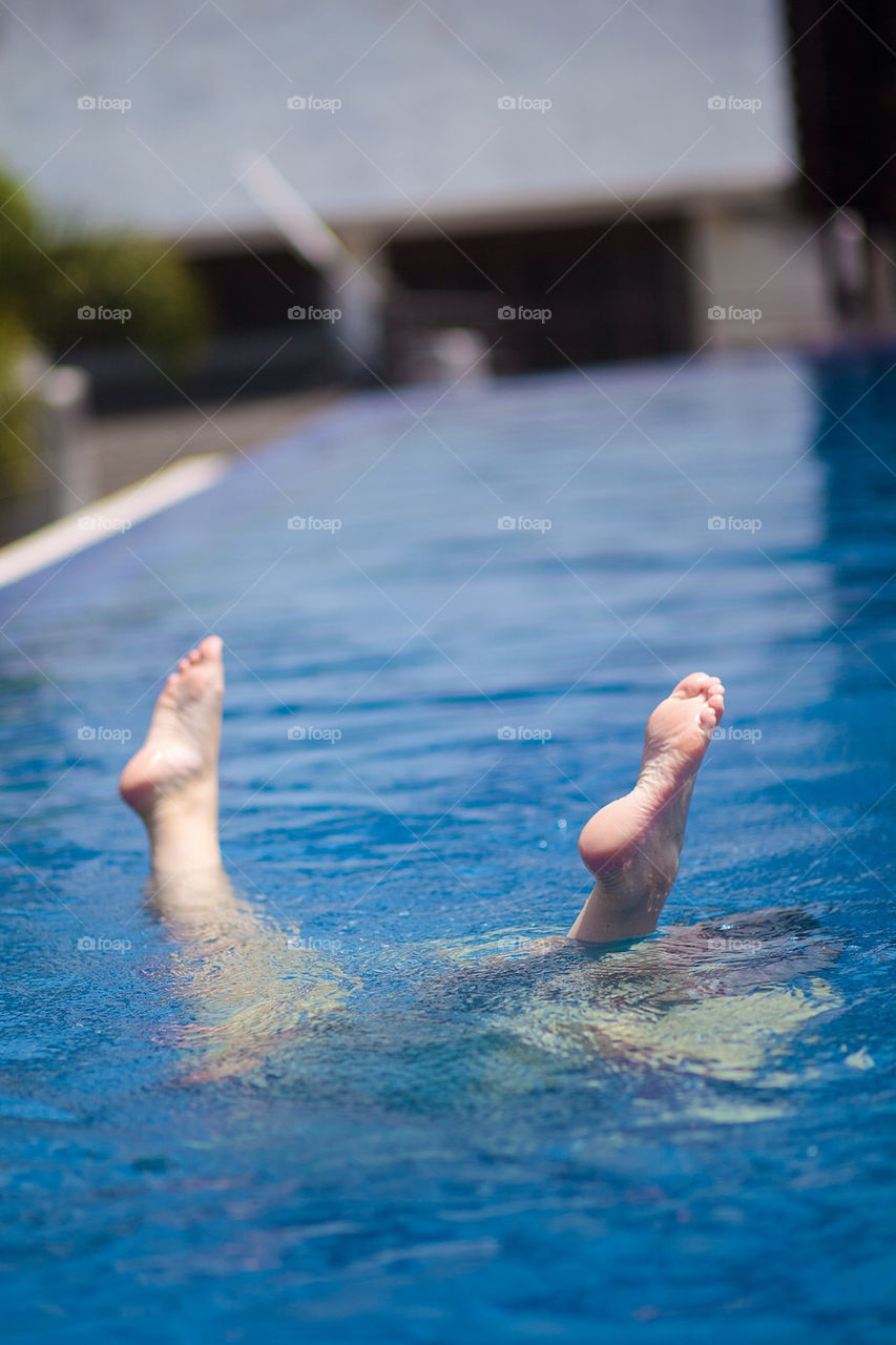 Feet sticking up through the pool surface