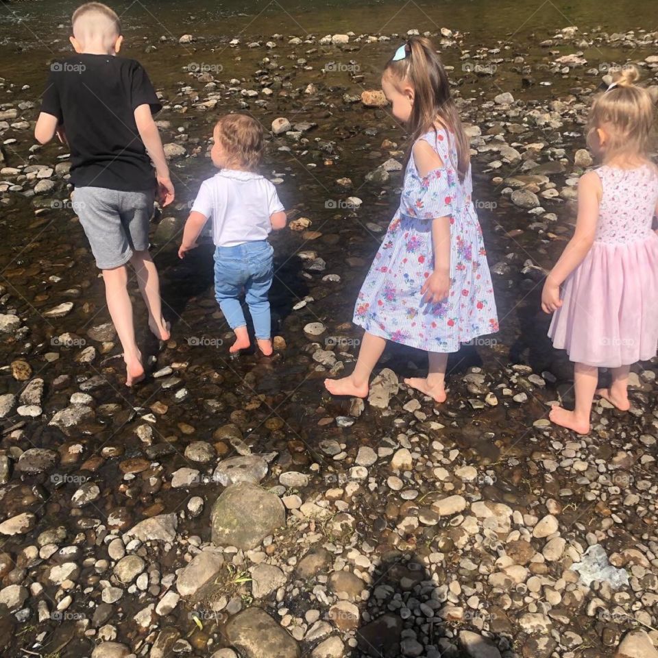 Children feeding there feet on nature’s water and stones 