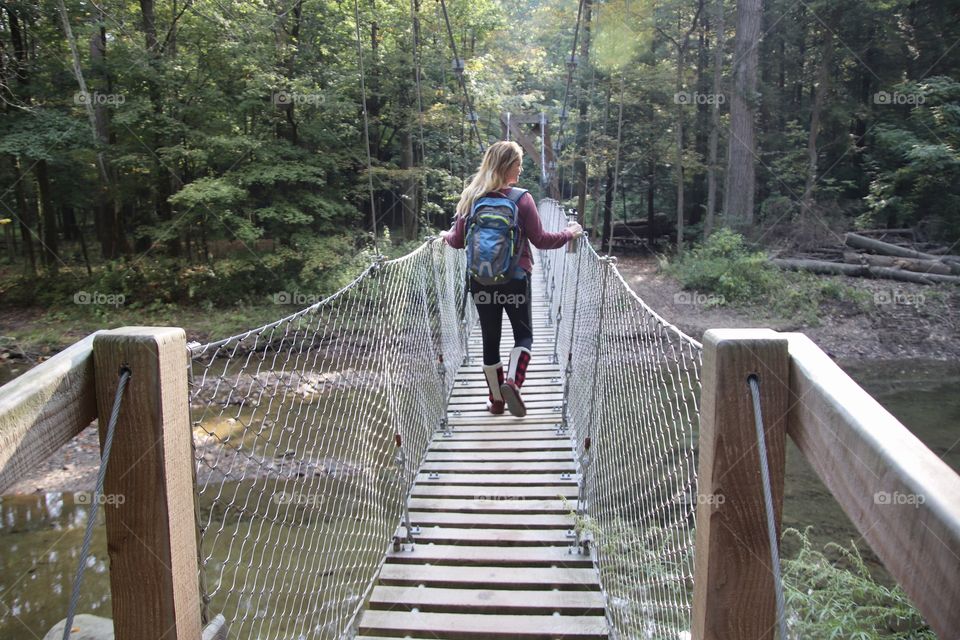 Woman hiking across bridge in Ohio, USA