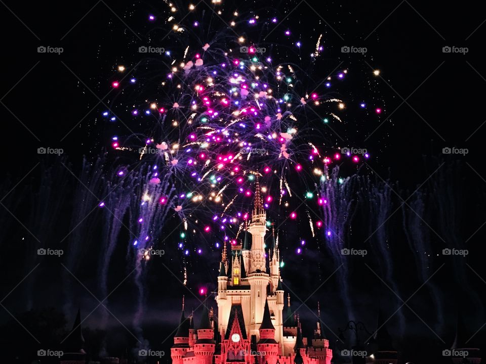 A bright and colorful explosion of fireworks behind Cinderella’s Castle in Disney World 