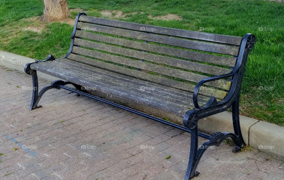 weathered bench on brick walkway