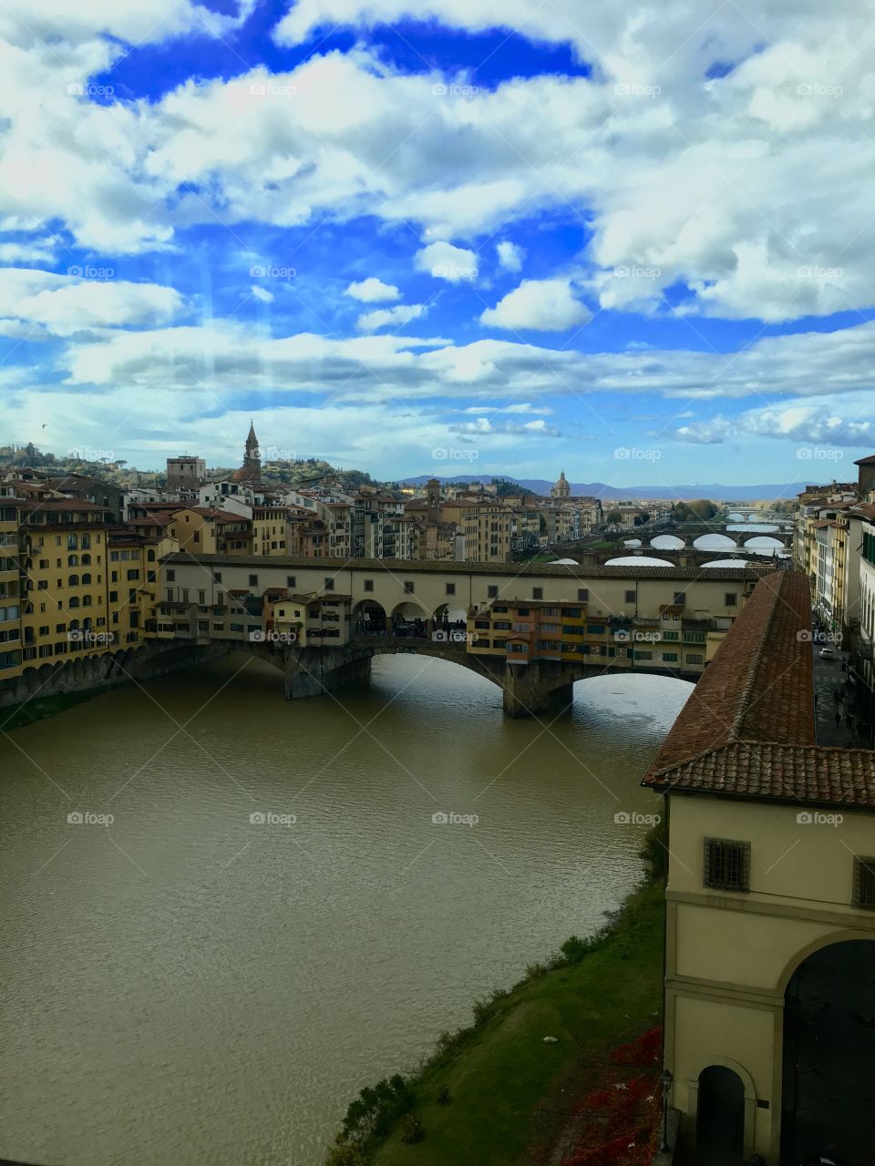 Every beautiful angle of Florence, Italy is a photogenic dream. This angle is from above, overlooking the layers of bridges in the background and the fresh blue sky.