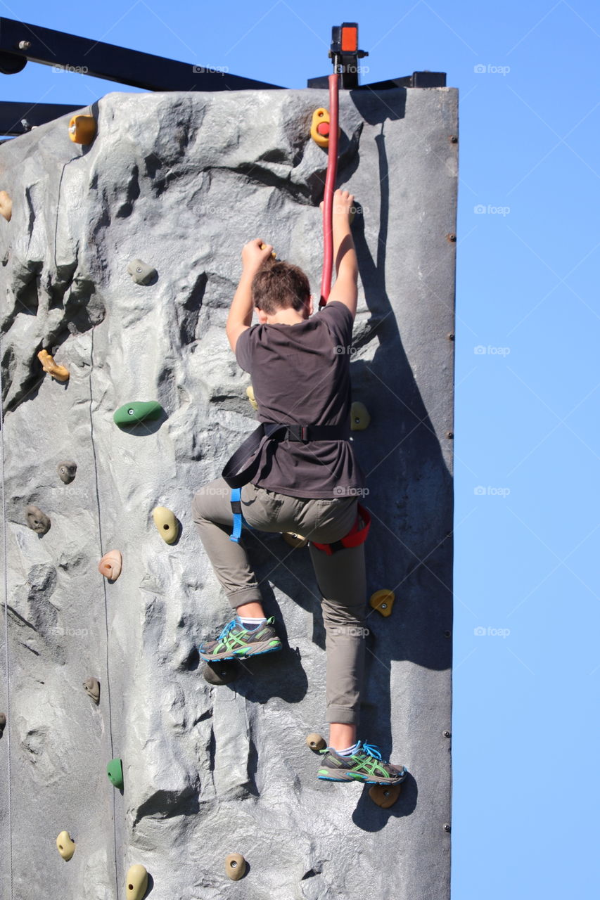 Major accomplishment boy rock climbing 