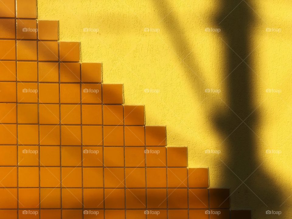 A simple wall can be very interesting when you apply different textures on it. The yellow stops being an overload, but becomes attractive. The lamppost shadow only adds to the effect.