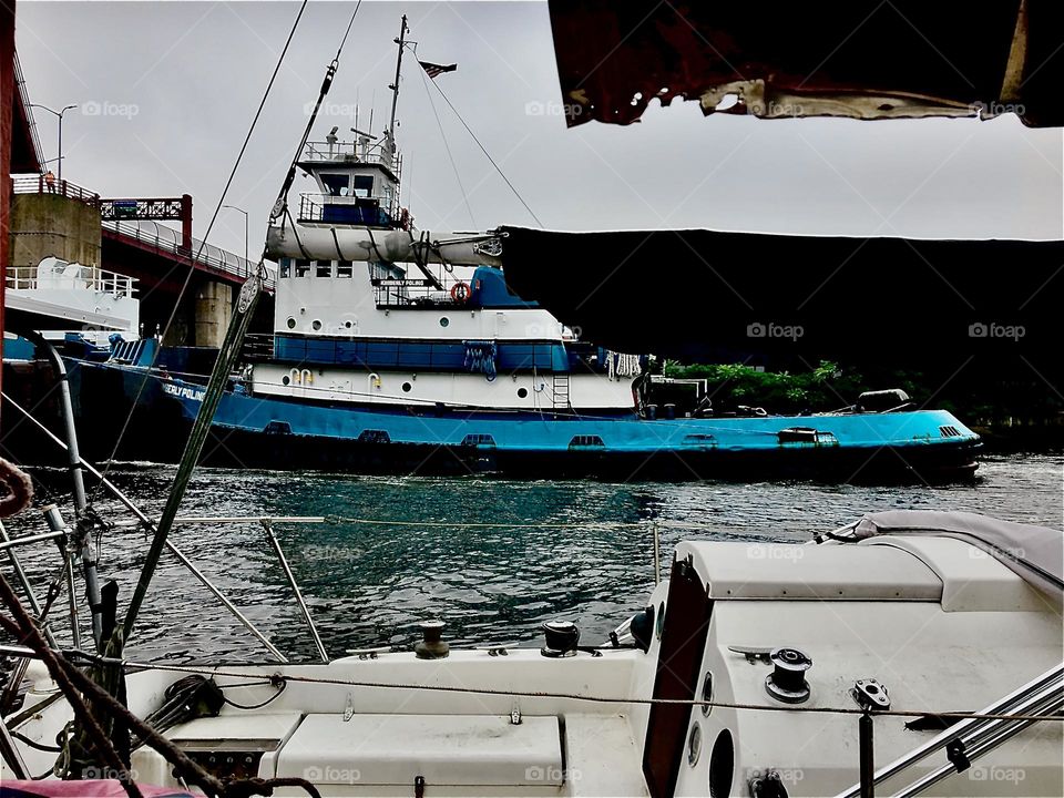 Boats in the waters of the East River at Newtown Creek in LIC, Queens, NY seen from above standing on the shore at low tide photographed on a late afternoon in December of 2021. Hypnotic Productions