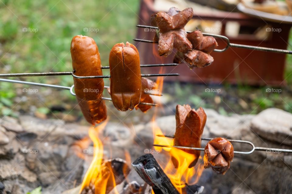 cooking the sausages and meat over the fire