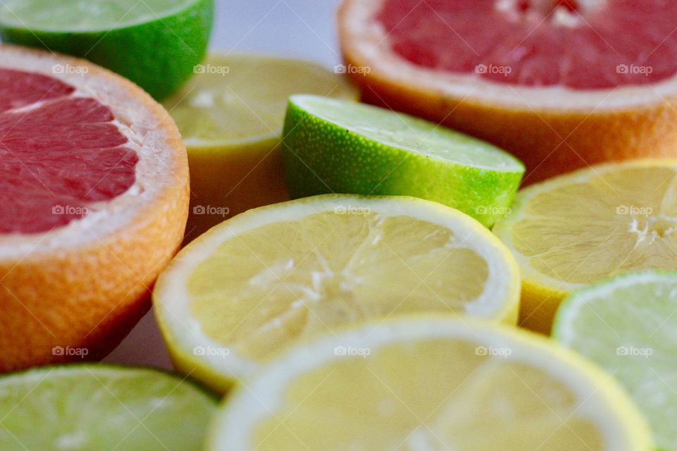 Still life of of grapefruit, lime and lemon halves on white background