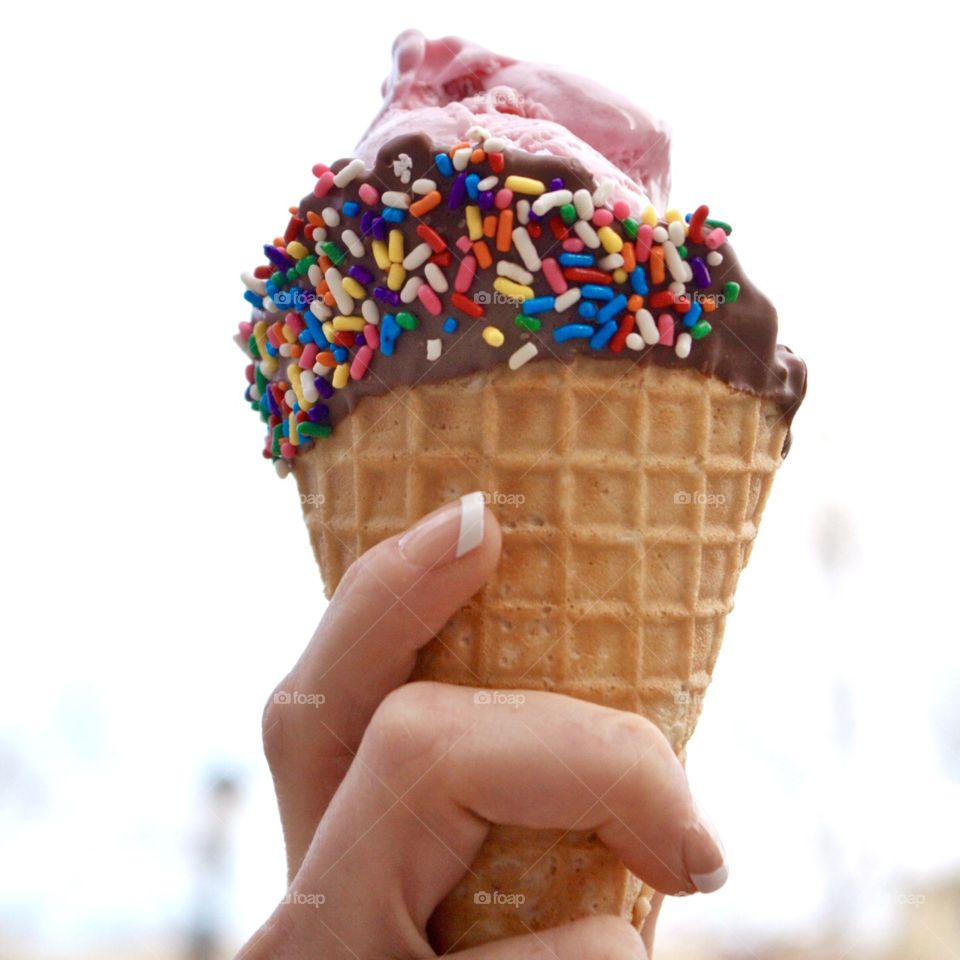 Strawberry Icecream with chocolate coating and colorful sprinkles in a waffle cone!