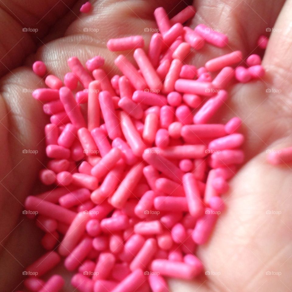 Hand holding pink sprinkles