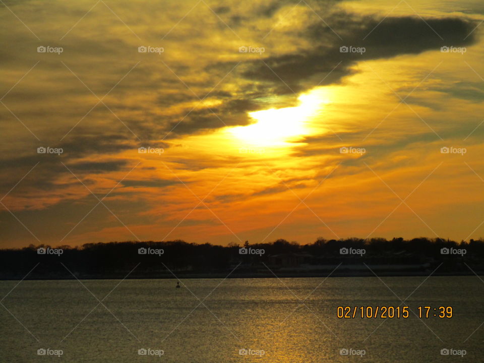  sun behind the clouds . Watching a winter's sunset in Riverside Rhode Island