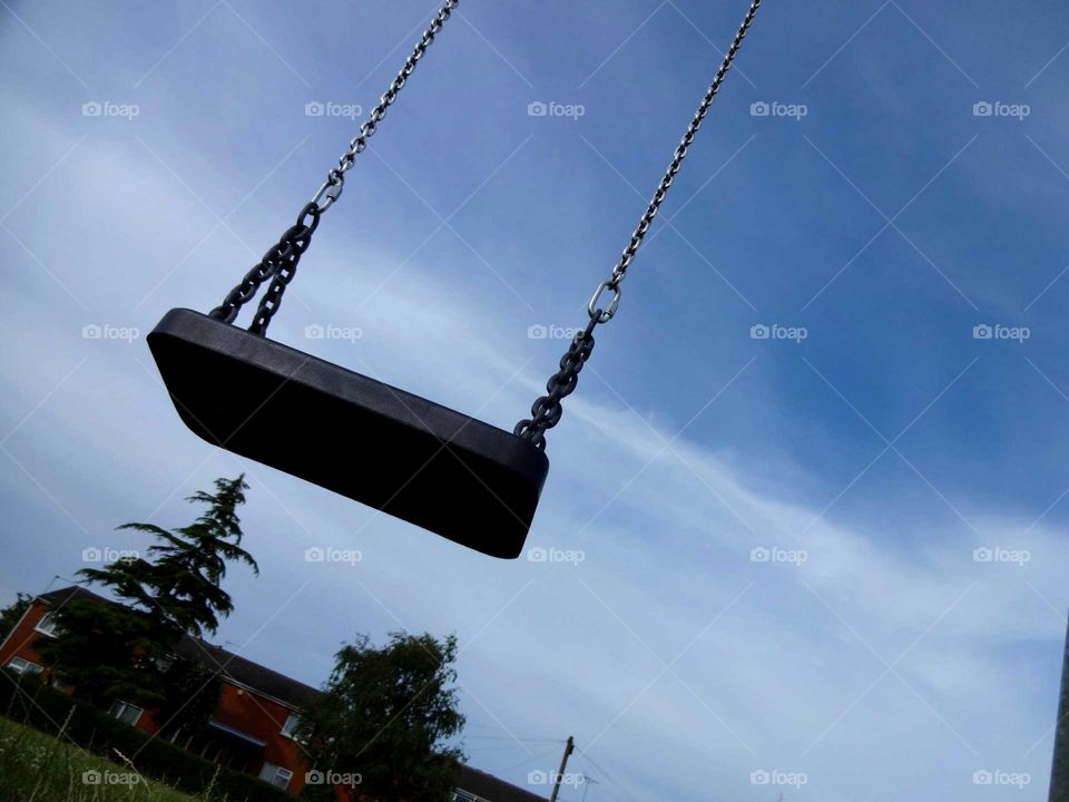 swing. lonely swing in the blue sky