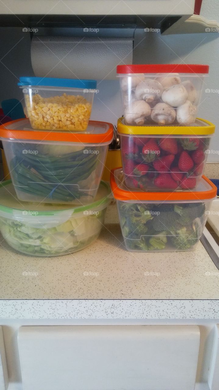 Vegetables and fruit in storage containers.