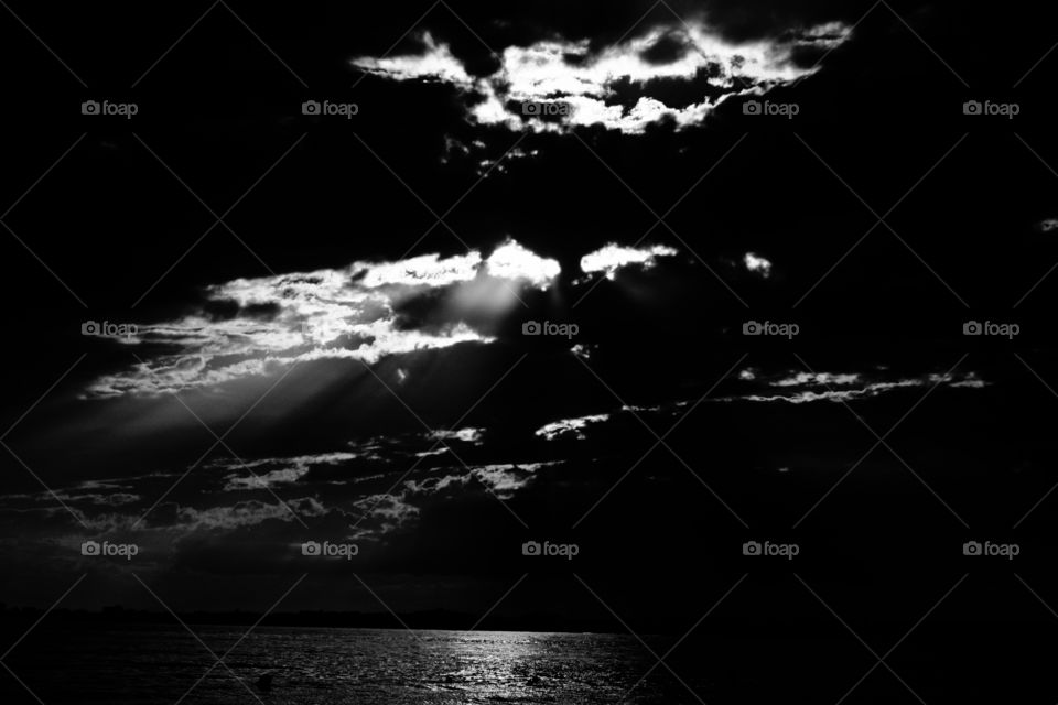 Black and white capture of a cloudy sky above the sea. Violent contrasts. A metaphor of the struggle of the human soul.
