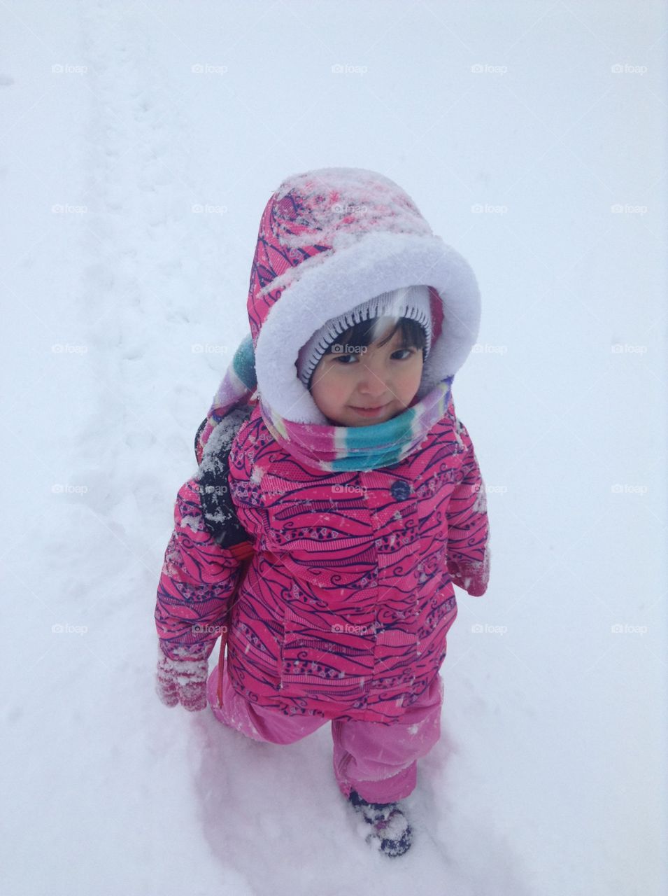 Little girl walking on snowy landscape