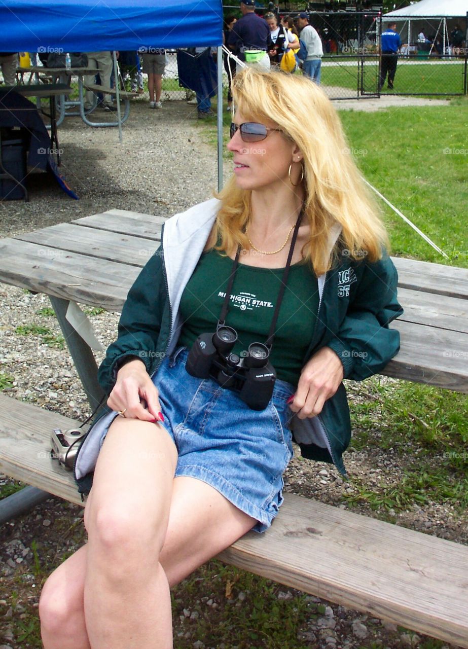 blonde woman sporting event binoculars jacket shorts