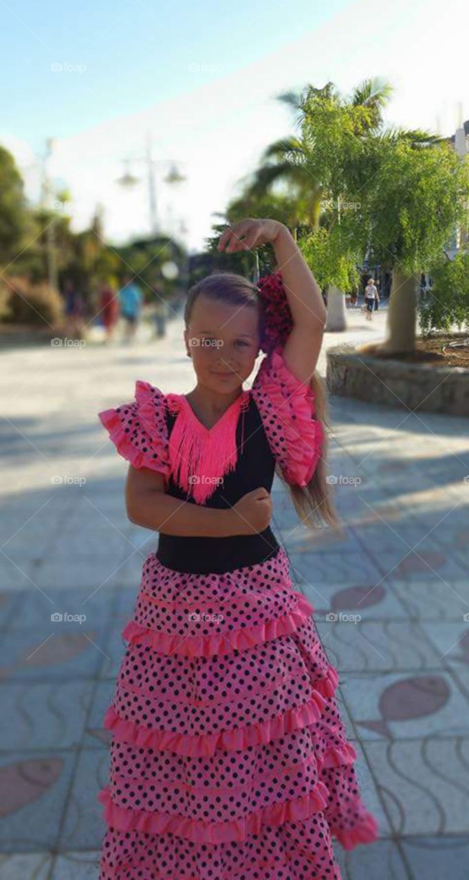 little girl, tourist wearing traditional souvenir Spanish dress in
Puerto de Morgan
Gran Canaria
Puerto de Mogán is a picturesque resort and fishing village in the municipality of Mogán, set at the mouth of a steep-sided valley on the southwest coast of the island of Gran Canaria. It attracts many tourists either to stay or on day-visits. Canals linking the marina to the fishing harbour have led to it being nicknamed "Little Venice" or the "Venice of the Canaries". Restaurants and bars fringe the marina and the beach front. On Fridays there is a very popular market which brings in tourists from all over the island.
Puerto de Mogán has very few buildings over two stories high, and the government of Gran Canaria restricts new buildings taller than this.
Puerto de Mogán can be reached via a new extension of the motorway GC1 (opened in March 2013) which