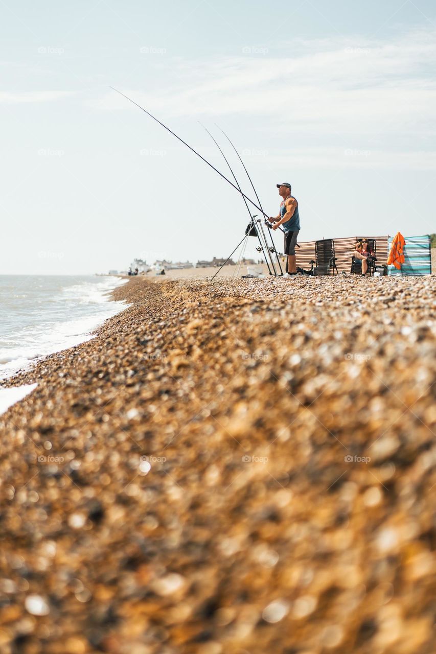Fisherman looking out to sea at Aldeburgh beach in England