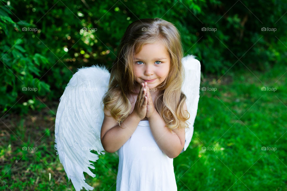 Little girl with angel wings and clapped hands