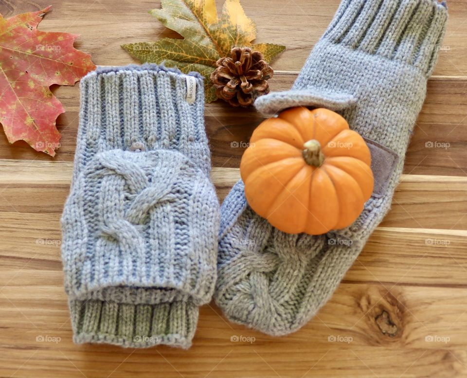 Autumn theme flat lay still life with mittens pumpkin and leaves