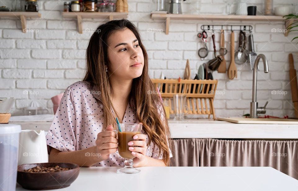 Woman Drinking Coffee in the Kitchen