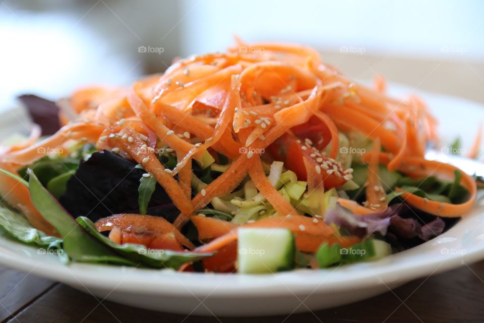 Carrot spaghetti on top of a salad 