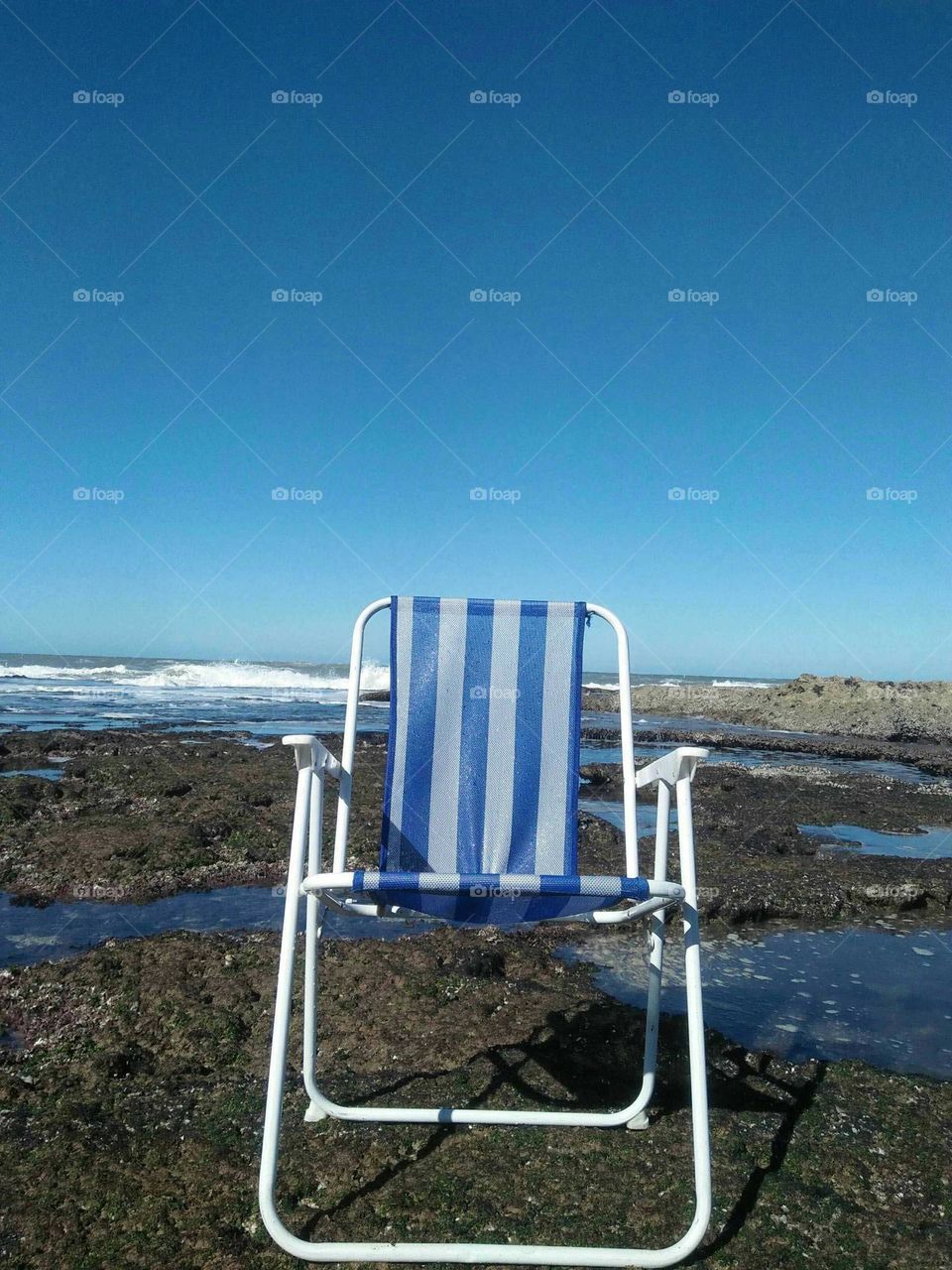 Beautiful armchair on the rock near a beach.