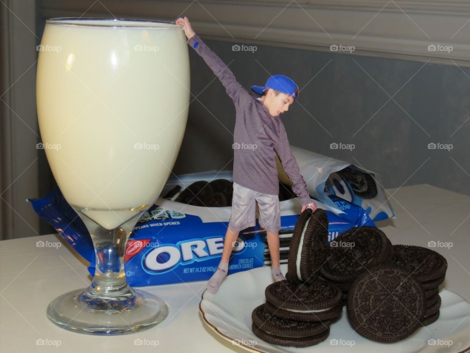 Miniature boy holding Oreo cookie