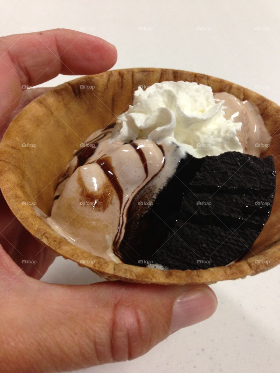 Summer desserts. Hand holding a waffle bowl filled with ice cream