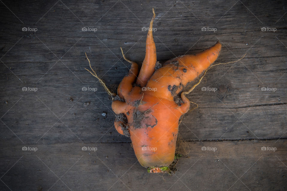 unusual shaped carrot on a wooden board 
