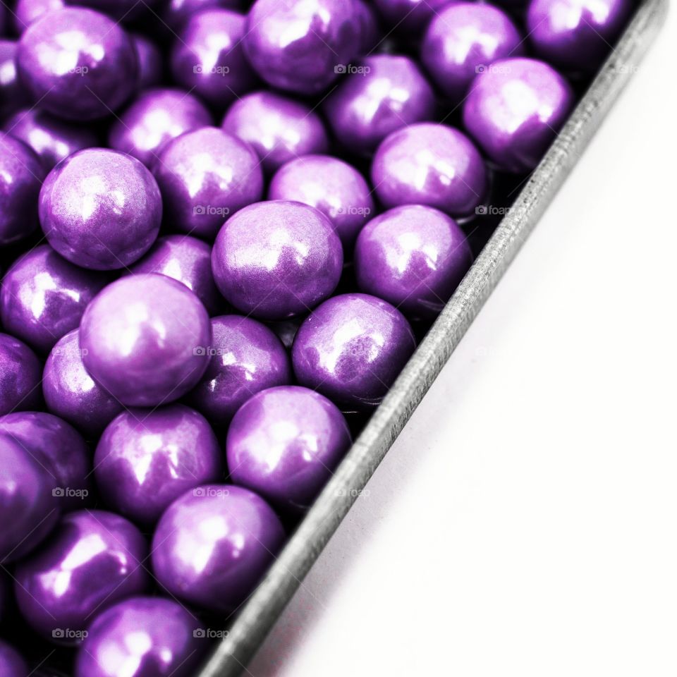 Purple candies in a galvanized tin tray.