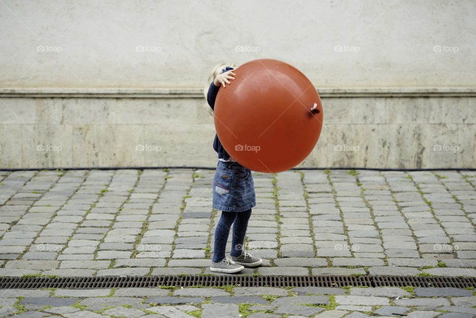 Girl holding a huge red ball