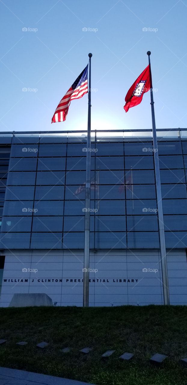 The American and the Arkansas flag in front of the William J Clinton Presidential Library.