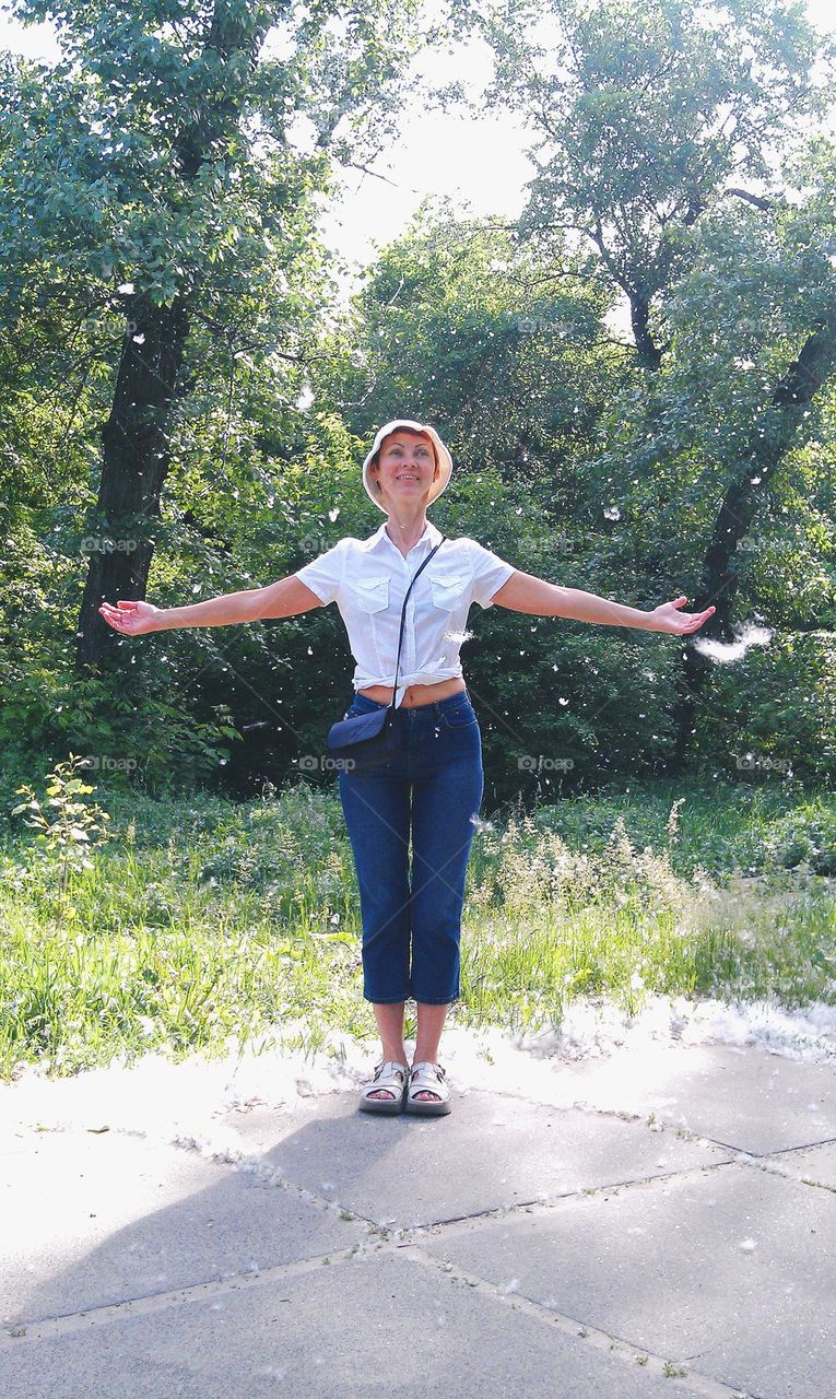 girl rejoices in poplar fluff in summer