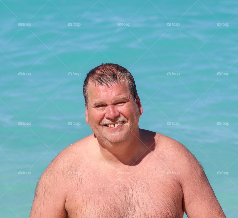 The model ,my husband.  My husband at Beach ,Green water a summer day.He is very happy about swimming and sun.