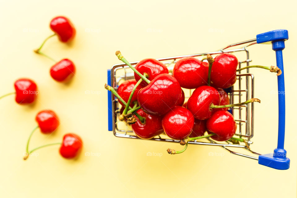 Fresh cherries lying in mini grocery cart