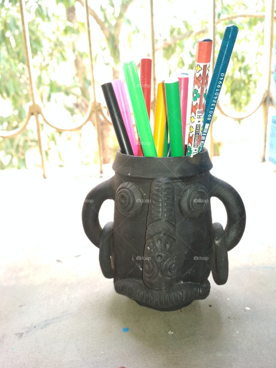 Beautiful black cup that is made by mud...it is use to keep pens ...& it also very useful for students.
