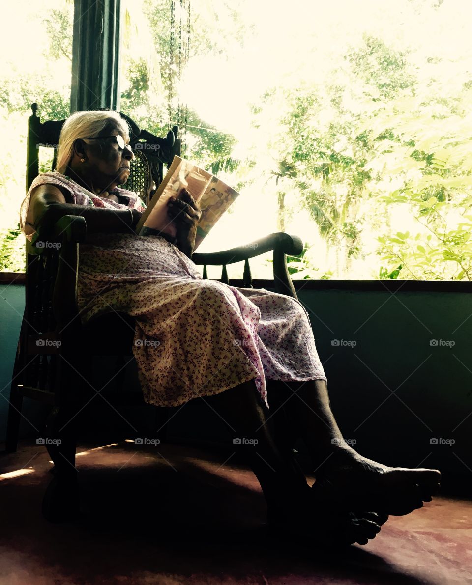 Senior woman reading a book in balcony