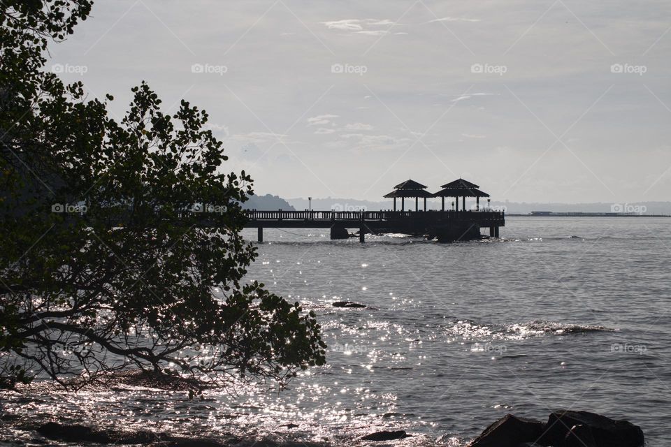 Jetty and beach at Pulau Ubin island in Singapore with sparkling water.