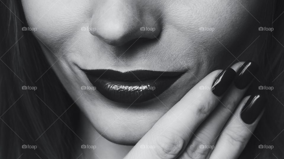 Close-up of woman's lip and finger nails