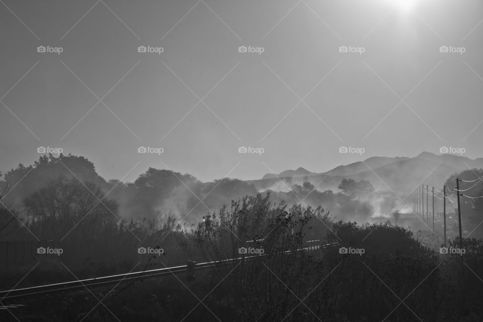 Smoke cloud hanging over train tracks after a wild fire burned everything aroumd