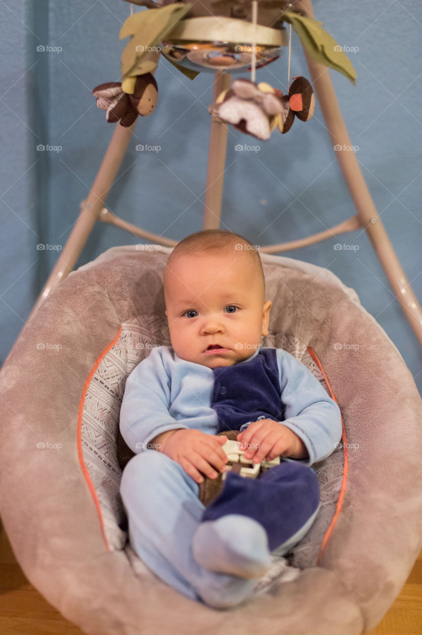 Cute baby boy in swing 