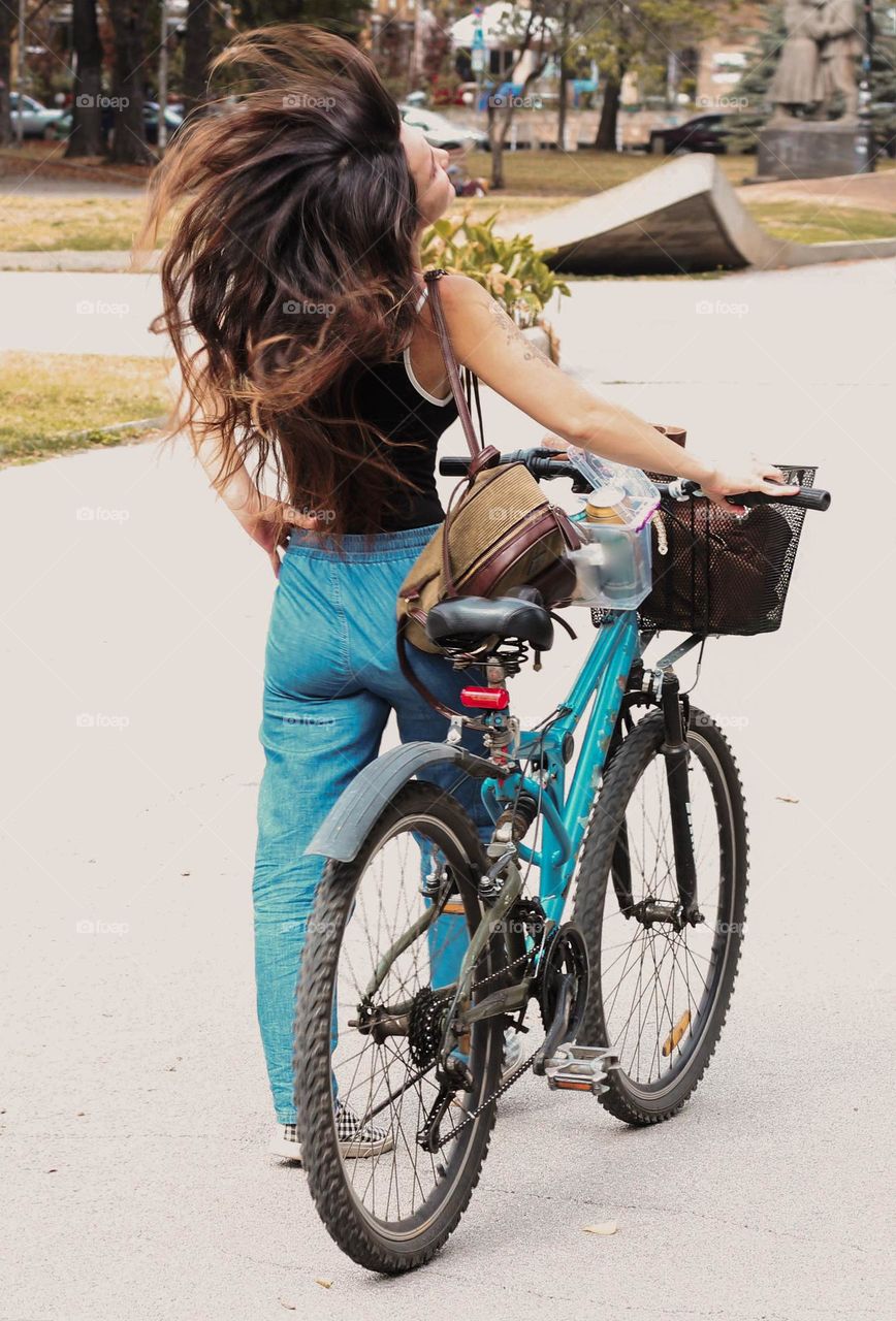 Woman at the street with bike and long hair, motion blur