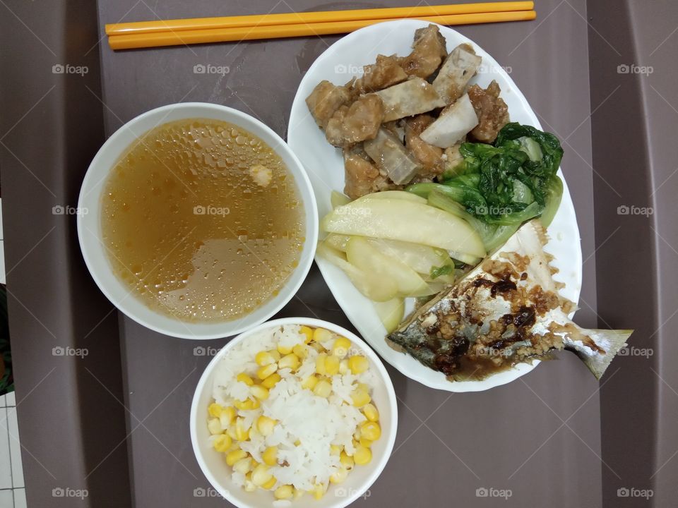 a set of dinner with rice sweet corn,and Chinese style soup