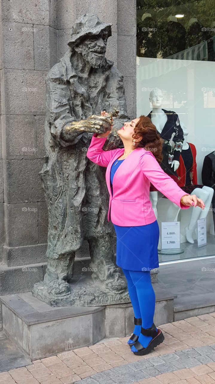 Woman posing in front of statue